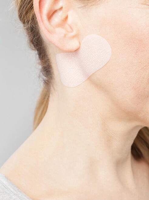 Femme appliquant Juzo ScarPad sur le cou