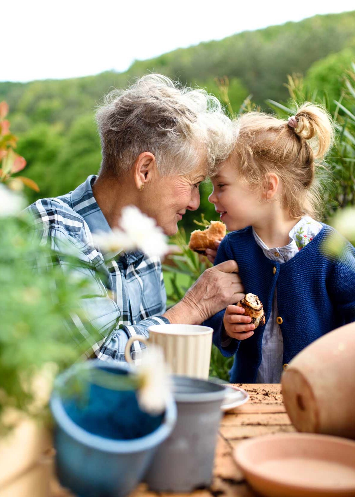 Eine Oma sitzt mit ihrer Enkeltochter im Garten
