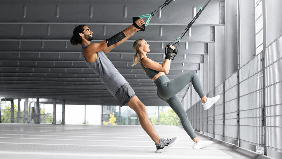 Bandages Un homme et une femme s'entraînent dans un parking souterrain avec une sangle TRX