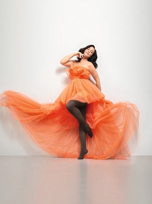 Lifestyle image Juzo Inspiration Woman with Juzo Inspiration and tights in cocoa and orange dress