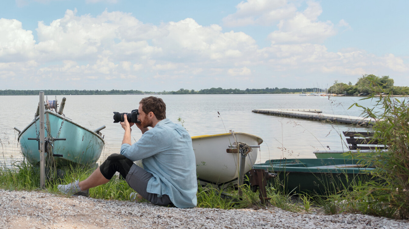 Ein Mann sitzt auf dem Boden und fotografiert. Er trägt eine Kniebandage. Ein Mann sitzt auf dem Boden und fotografiert. Er trägt eine Kniebandage.