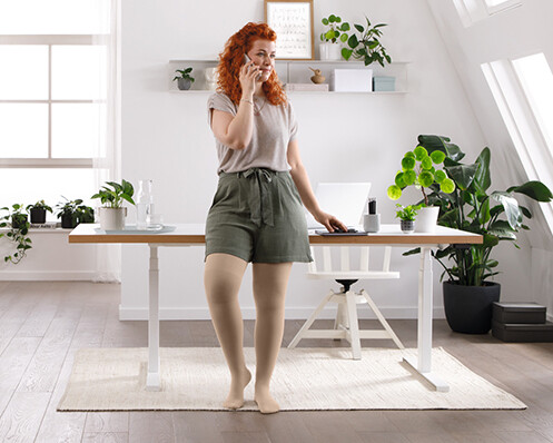 A woman is standing in her living room, talking on the phone A woman is standing in her living room, talking on the phone