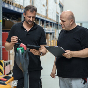 Logistikzentrum Zwei Männer stehen in einem Logistikzentrum