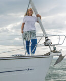 A woman with lymphoedema is standing on the deck of a boat. She is wearing blue compression stockings A woman with lymphoedema is standing on the deck of a boat. She is wearing blue compression stockings
