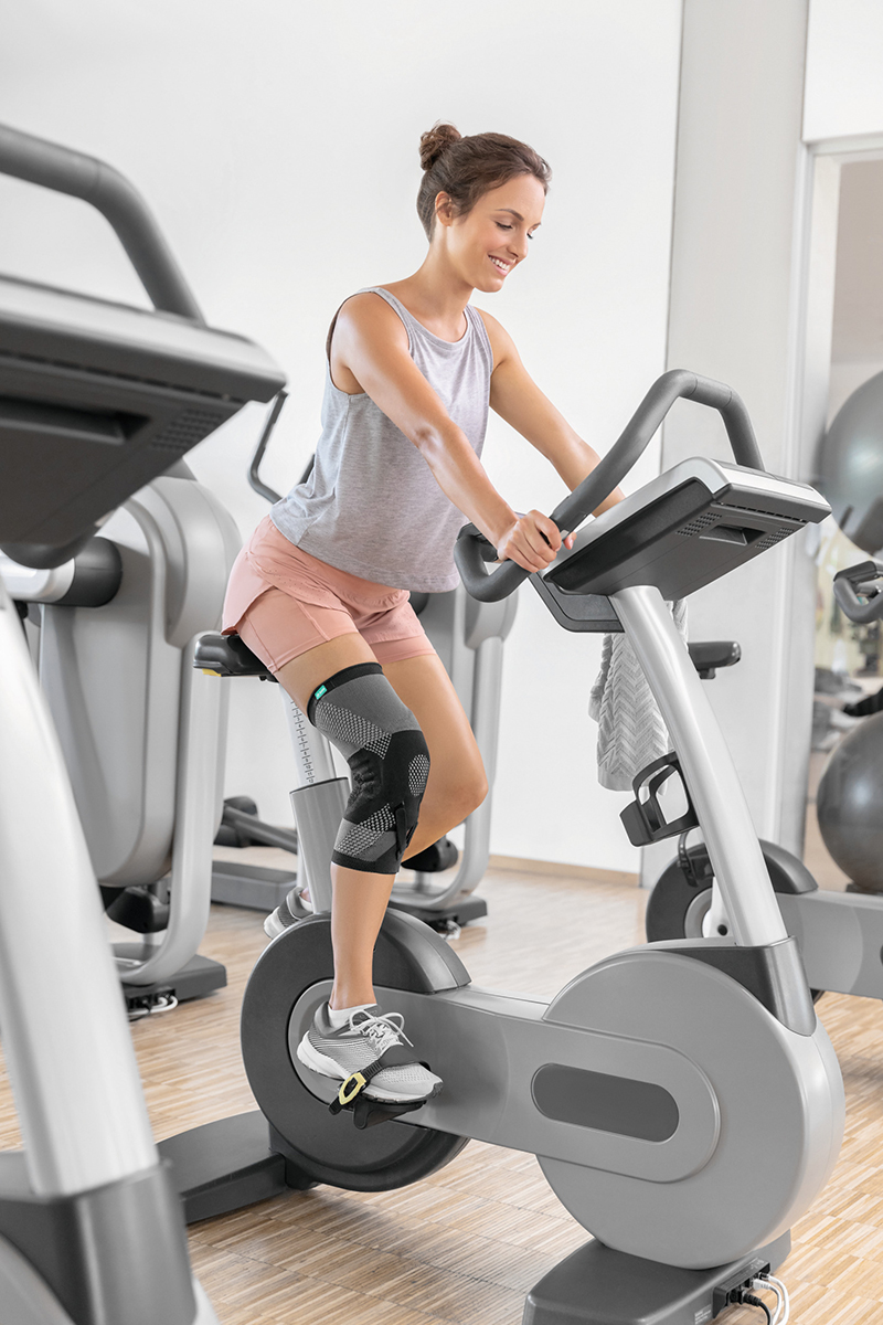 A woman in a gym wearing a knee brace